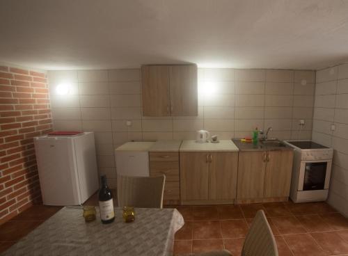 una cucina con frigorifero e tavolo con una bottiglia di vino di Cicvaric rooms a Virpazar