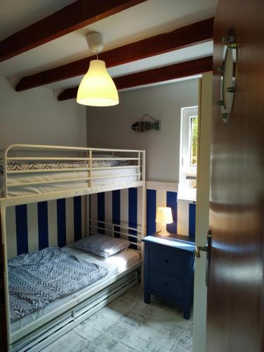 een slaapkamer met een stapelbed met blauwe en witte strepen bij Ustka - Komfortowy domek nad morzem in Przewłoka