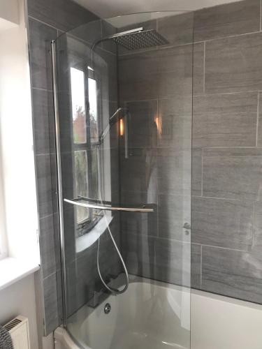 a shower with a glass door in a bathroom at 3 Crown Barton, Glastonbury in Glastonbury