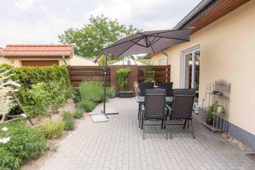 a patio with a table and an umbrella at Havel Ferienhaus Brandenburg, Nähe Beetzsee in Butterlake