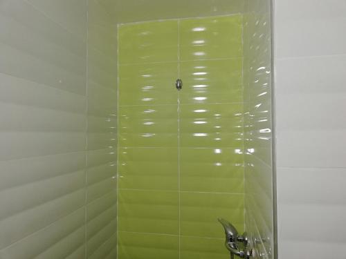 y baño con cabina de ducha con azulejos verdes. en Hotel School Ersat Azrou en Azrou