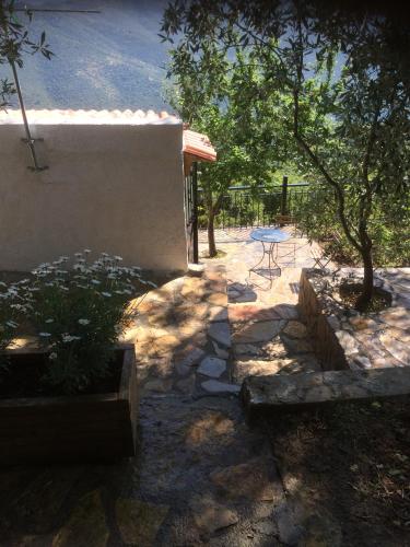 a stone patio with a table and a tree at Gourgiana Apartments in Andritsaina