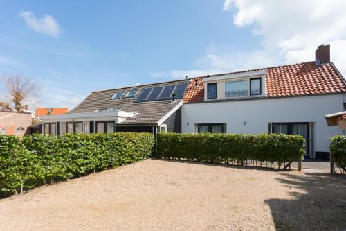 a white house with solar panels on the roof at De Dorsvloer in Domburg