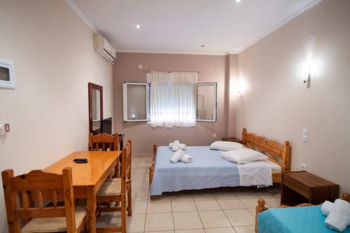 a bedroom with a bed with a teddy bear on it at Irini seaside studios in Nikiana