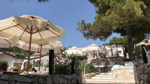 a group of umbrellas sitting on a stone wall at Apartments Villa Macola in Trogir