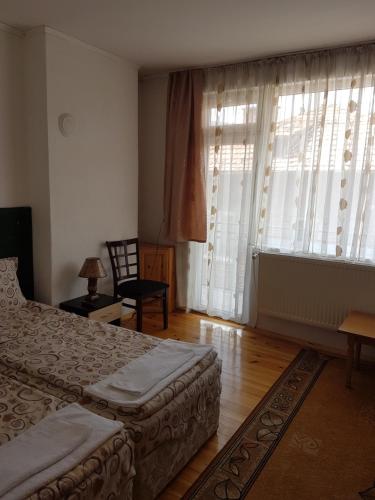 a bedroom with two beds and a large window at Yana Guest House in Dobrinishte