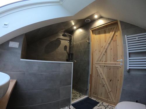 een badkamer met een douche en een houten deur bij Apartament Sady przy Ślęży in Marcinowice