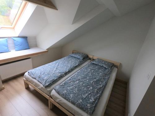 - une chambre mansardée avec 2 lits et une fenêtre dans l'établissement Apartament Sady przy Ślęży, à Marcinowice