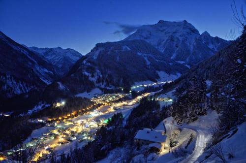 a view of a town in the mountains at night at Pension Rosenegg in Finkenberg