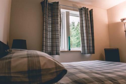 a bedroom with a bed and a window at Drumlochy B&B in Inverness