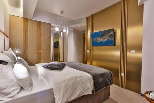 a bedroom with a large white bed with white pillows at Hotel Fagus by Aycon in Budva