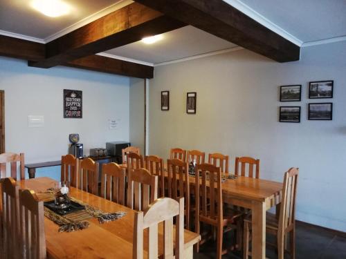 une salle à manger avec une table et des chaises en bois dans l'établissement Hostal La Base, à Puerto Natales