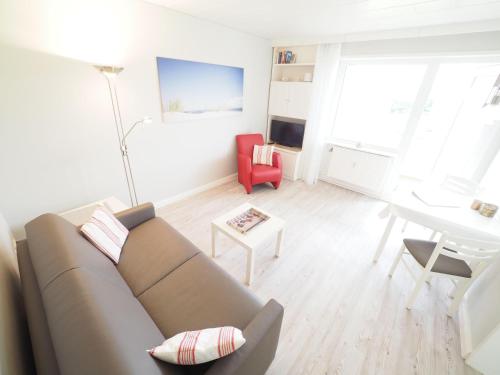 uma sala de estar com um sofá e uma mesa em Appartement-67 em Westerland