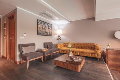 a living room with a couch and a table at Orka Cove Hotel Penthouse & Suites Adults Only in Fethiye