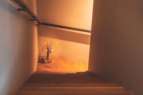 a stairway with a vase with flowers in it at Orka Cove Hotel Penthouse & Suites Adults Only in Fethiye