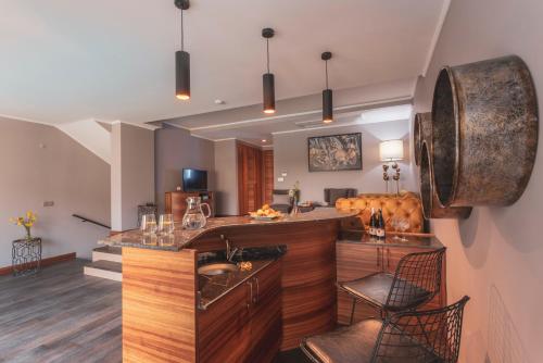 a kitchen with a bar with a sink and chairs at Orka Cove Hotel Penthouse & Suites Adults Only in Fethiye