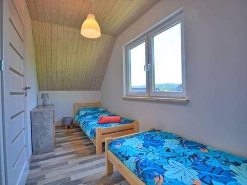 two beds in a room with two windows at RESET INN in Zawóz