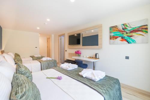 a hotel room with two beds and a sink at AMOSSİA Elite Boutique Hotel in Turunc