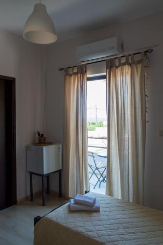 a bedroom with a bed and a table and a window at Rooms Kochilas Elafonisi in Elafonisi