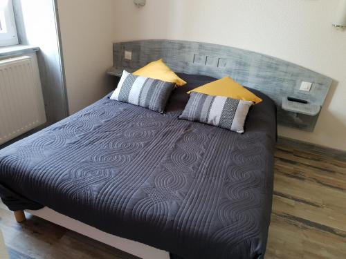 a bedroom with a large bed with two pillows at Le Chalet au bord du lac in Gérardmer