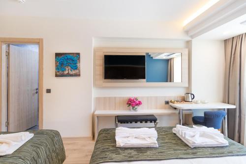 a hotel room with two beds and a desk at AMOSSİA Elite Boutique Hotel in Turunc