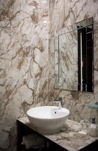 a bathroom with a white sink and a mirror at Julina Boutique Living in Mosta