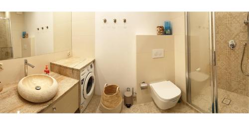 a bathroom with a toilet a sink and a shower at Apartament North Coast - nad morzem in Gdańsk
