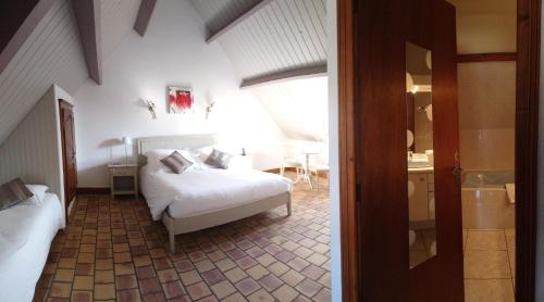 a bedroom with a bed and a table in a room at L'Orée des Chênes, The Originals Relais (Relais du Silence) in La Ferté-Saint-Aubin