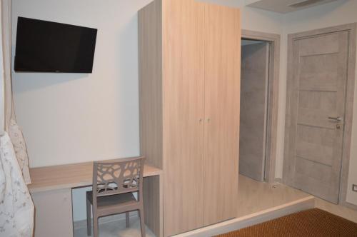 a bedroom with a desk with a tv and a chair at Sotto il Cielo del Cilento in Ostigliano