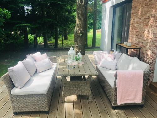 a patio with two couches and a table on a deck at Vila EVIO Třeboň in Třeboň