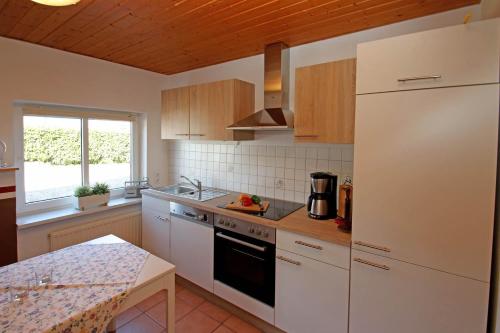 a kitchen with a white refrigerator and a counter at Ostsee Reetkate in Langballig