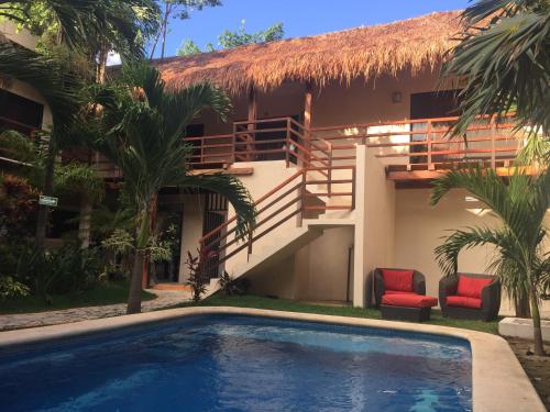 a resort with a swimming pool in front of a building at Hotel Uolis Nah in Tulum