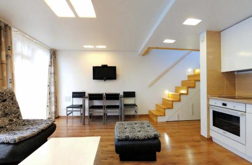a living room with a couch and a table with a tv at Smiltelės Apartamentai Booking Palanga LT in Palanga