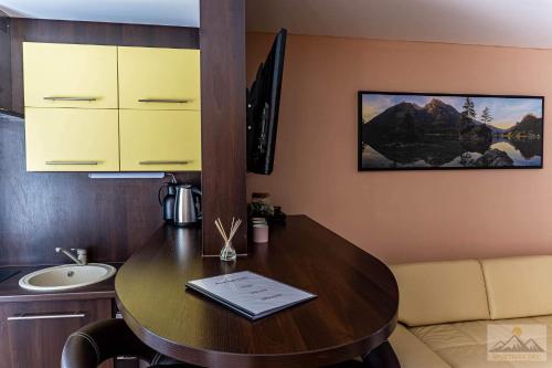 um quarto com uma mesa de madeira, um lavatório e um balcão em Apartment Eric,High Tatras em Dolný Smokovec
