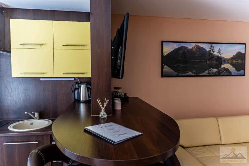 a room with a wooden table and a sink and a counter at Apartment Eric,High Tatras in Vysoké Tatry