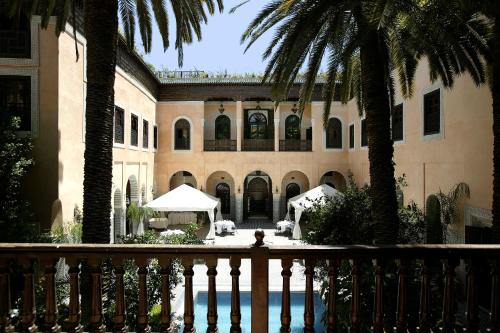 a building with palm trees in front of it at Palais Shéhérazade & Spa in Fez