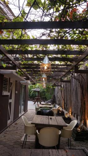 a patio with a wooden table and chairs and a chandelier at Kinta Bali Villa in Ipoh