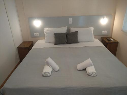 a bedroom with a large bed with two towels on it at Despoina Rooms in Tsoukalades