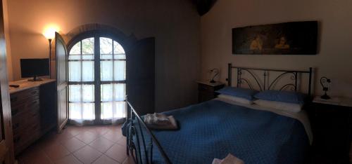 a bedroom with a blue bed and a window at Podere Badia Valdrago Agriturismo Mugello Circuit in Scarperia