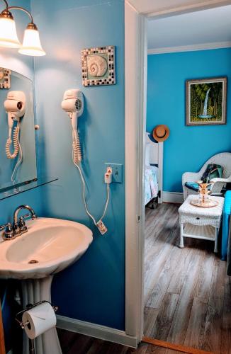 a blue bathroom with a sink and a mirror at Chelsea Pub and Inn in Atlantic City