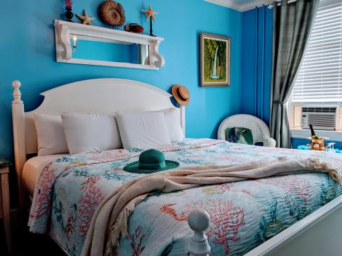a blue bedroom with a bed with a hat on it at Chelsea Pub and Inn in Atlantic City