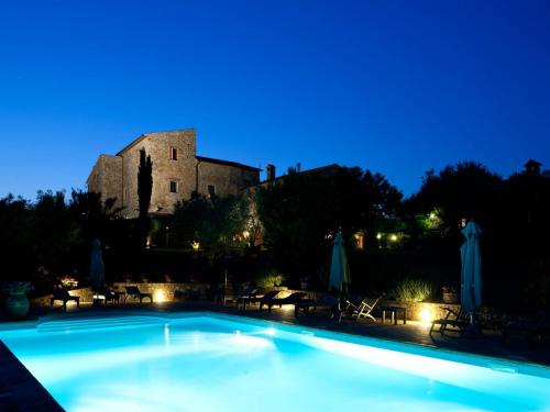 a swimming pool in front of a castle at night at Tenuta Di Canonica in Todi