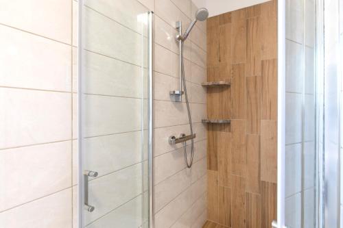 baño con cabina de ducha con puerta de cristal en Villa Magdalena, en Porat