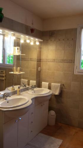a bathroom with two sinks and a mirror at L'étape Provencale in Cabriès