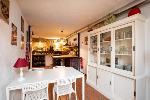 a kitchen with white cabinets and a table and chairs at VILLA ZENITH Hostel - LA MAISON in Lacanau