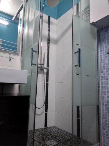une douche avec une porte vitrée dans une salle de bain dans l'établissement NIBENAMA, à Gérardmer