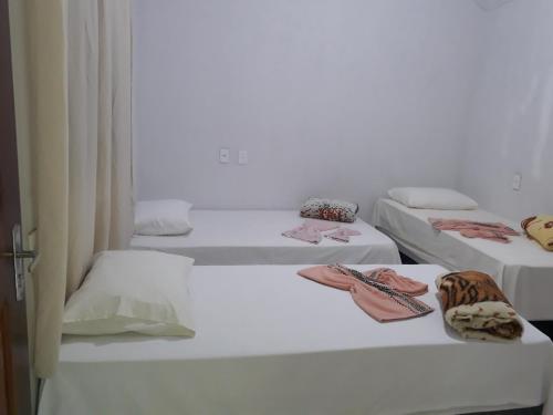 a group of three beds in a room at Pousada Mãe e Filhas in Mateiros