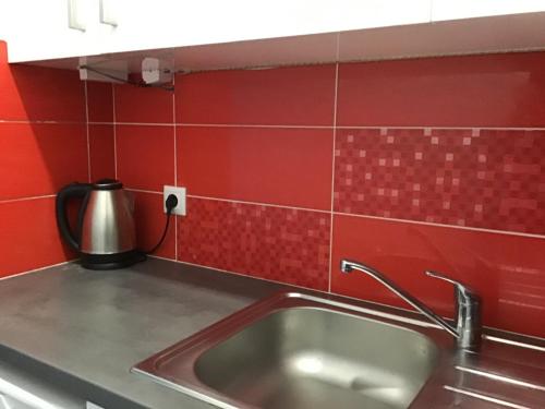 a kitchen with a sink and a red tiled wall at Summer Studio - Zakynthos!! in Argassi