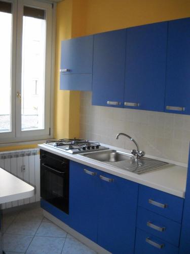 uma cozinha azul com um lavatório e um fogão em Casa vacanze IL VIOLINO em Cremona