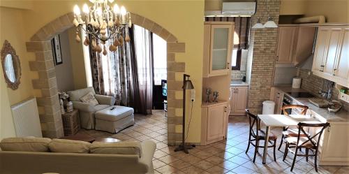 a living room and kitchen with a couch and a table at Sandy's Home in Kolymvari